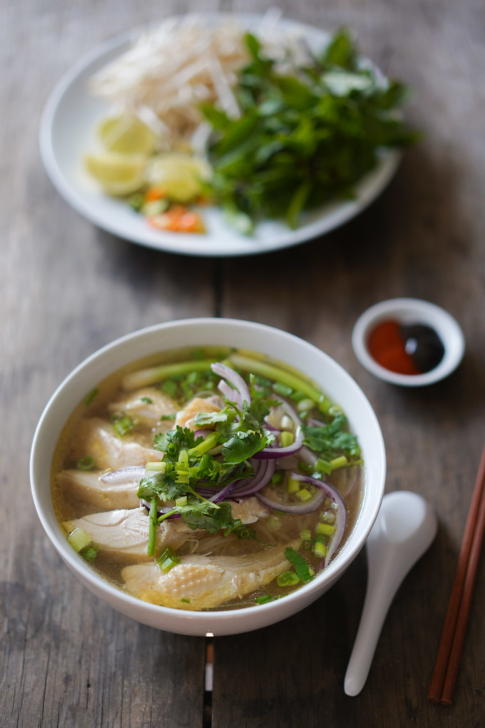 bowl of pho ga with herbs and dipping sauce