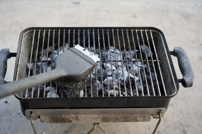 scrubbing bbq grates with cleaning tool