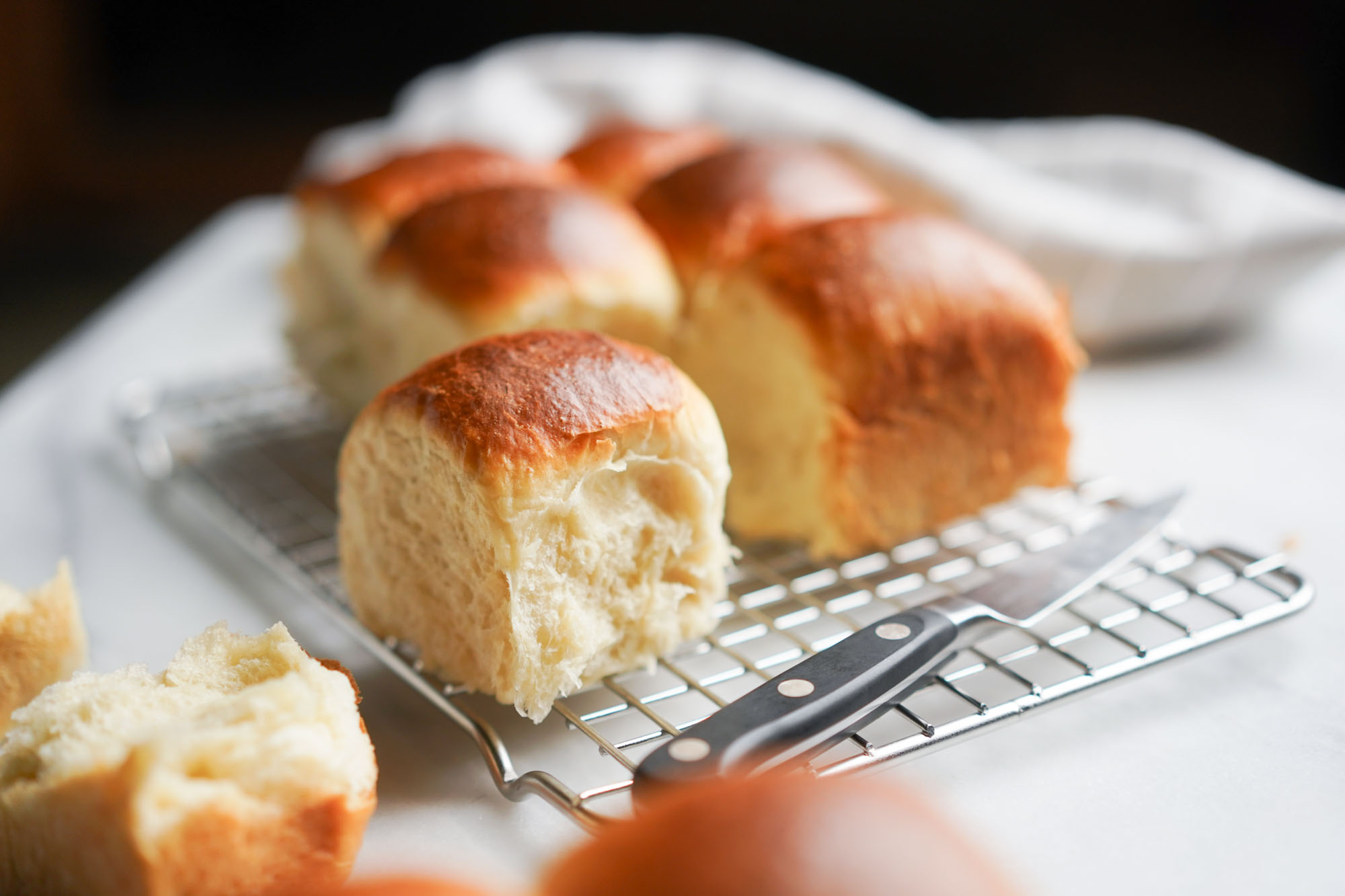 Japanese milk bread rolls cooling on a rack