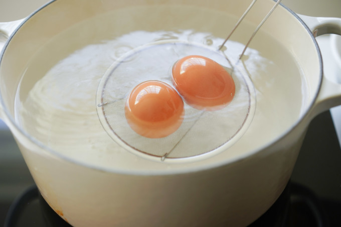 lowering eggs into boiling water