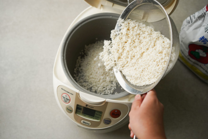pouring sticky rice into rice cooker