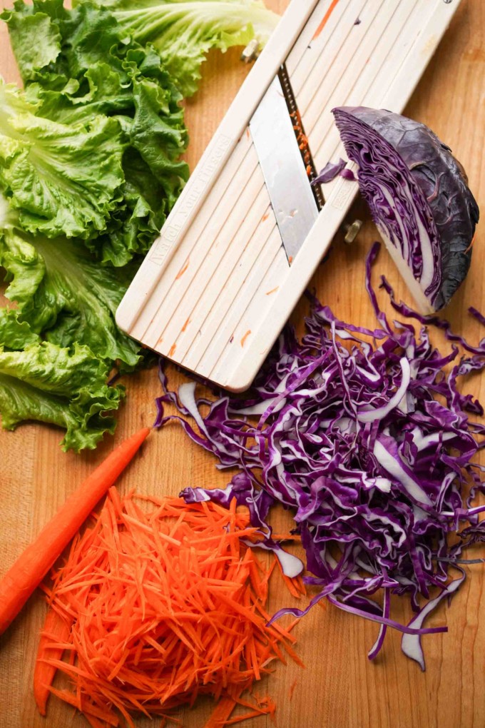 shredded lettuce, cabbage, and carrots with a mandolin slicer