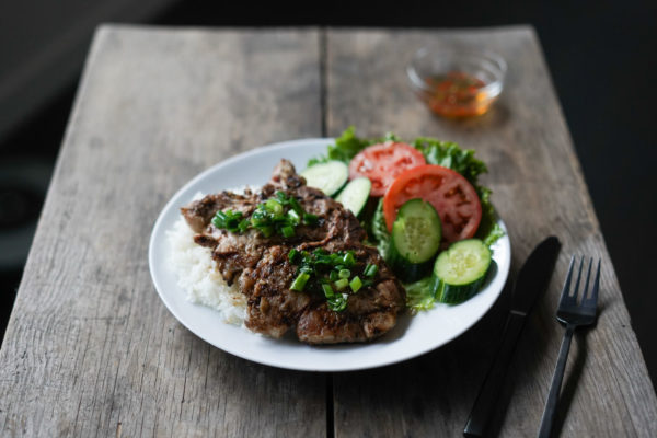 plate of 2 Vietnamese sườn nướng with rice, and veggies